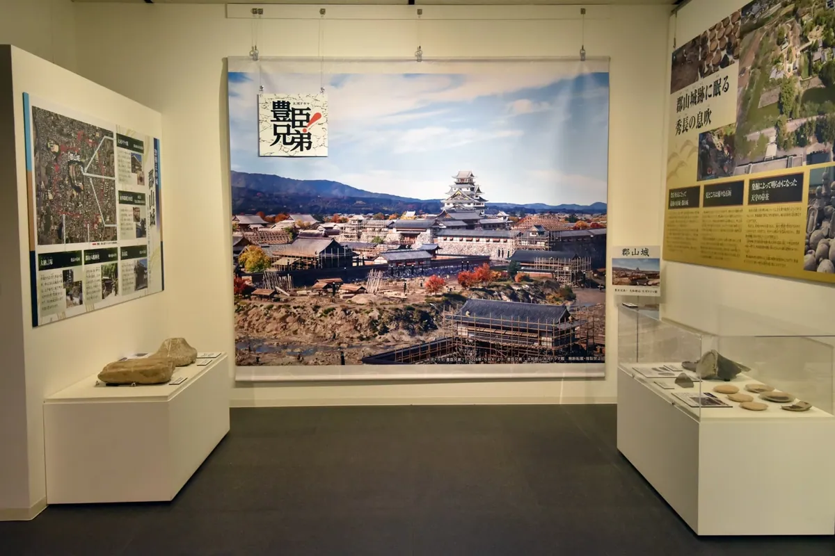 郡山城の大きな写真パネルと出土品が並ぶ郡山歴史展示ゾーン