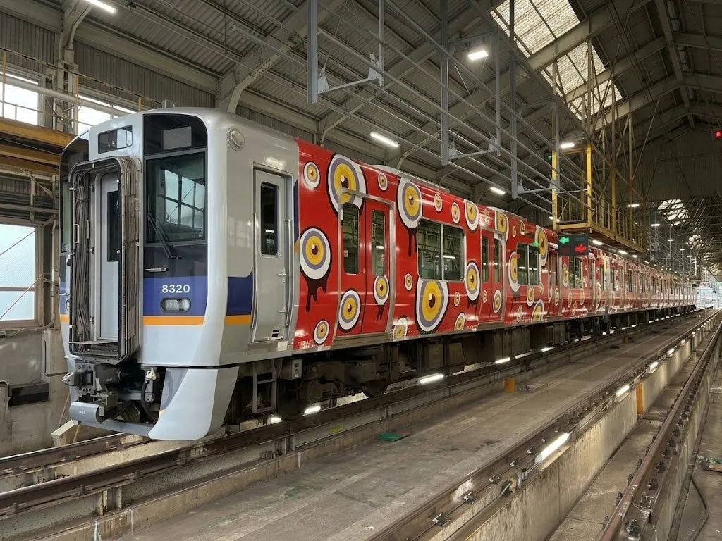 赤地に大小の目玉が描かれた南海8300系のラッピング車両