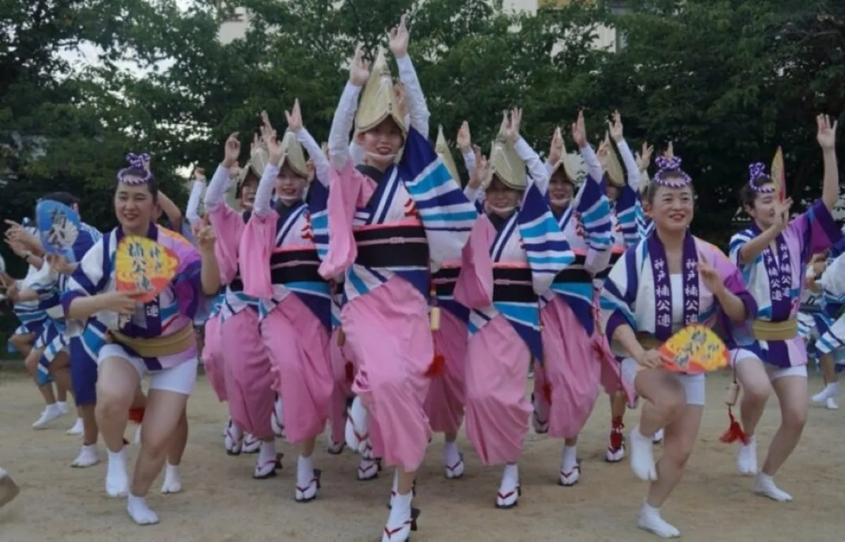 扇子を手に笑顔で踊る、神戸の楠公連の踊り手たち