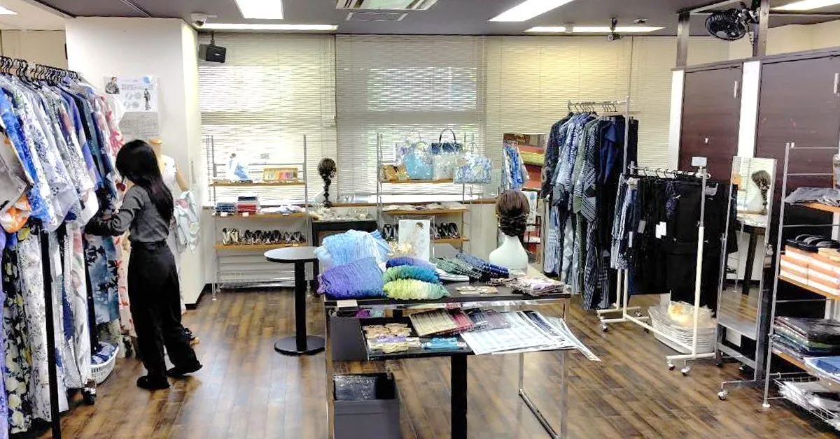 Racks of kimono and yukata, and tables of obi and accessories inside the sale venue