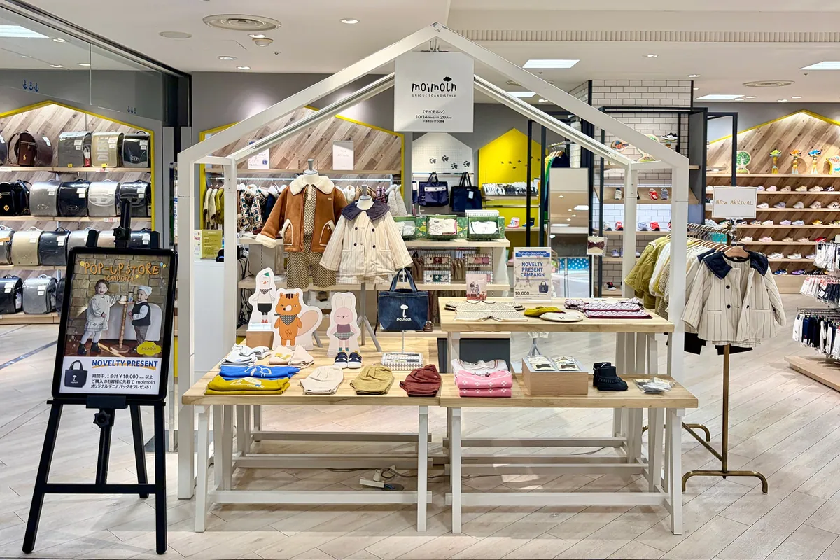 ハウス型の什器にベビー服やニット帽、バッグが並ぶ、大丸神戸店のモイモルン期間限定ショップ