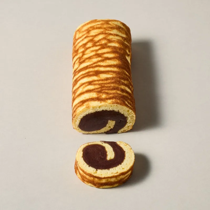 Tora-gawa roll with a tiger-stripe pattern on sponge cake skin, wrapped around bean paste, with a cut cross-section