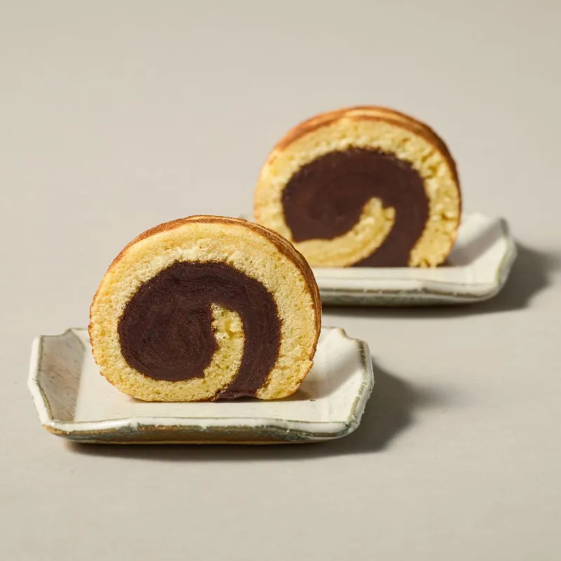 A cross-section of a tora-gawa roll with a spiral of bean paste, on small plates