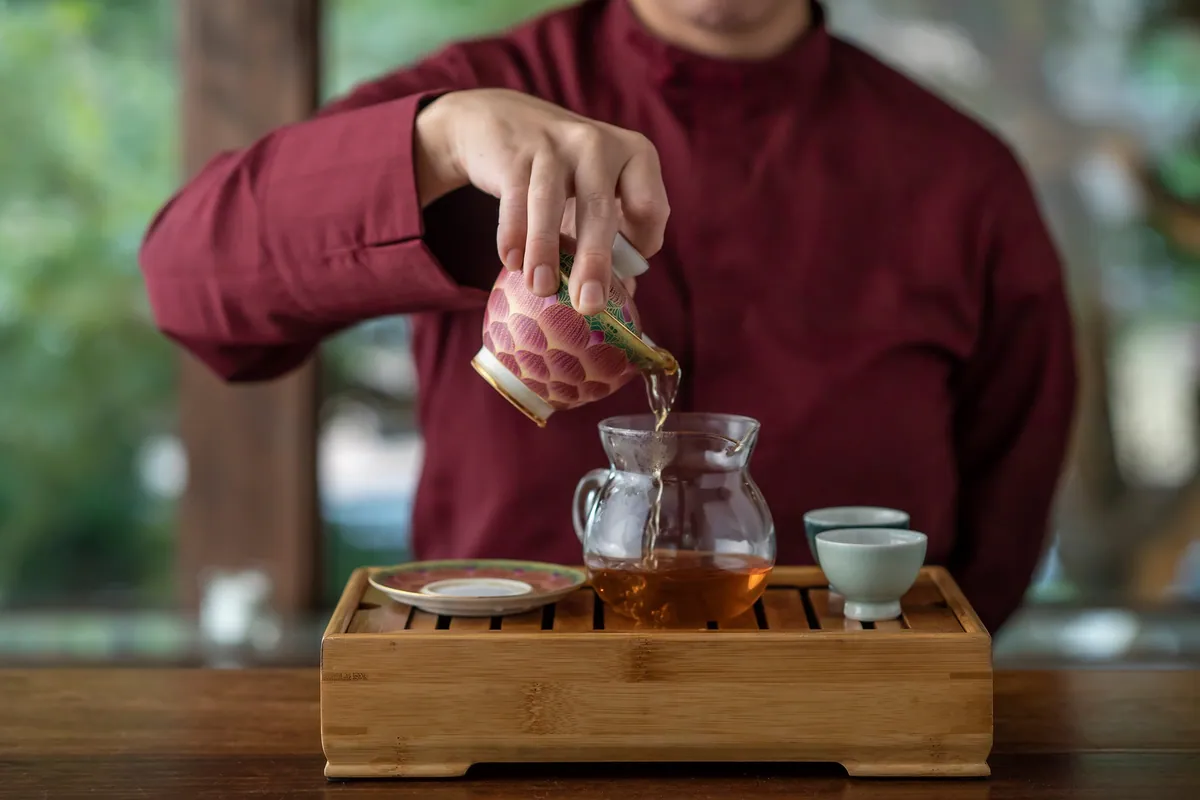 茶艺师把茶从茶壶倒入公道杯的中国茶服务场景