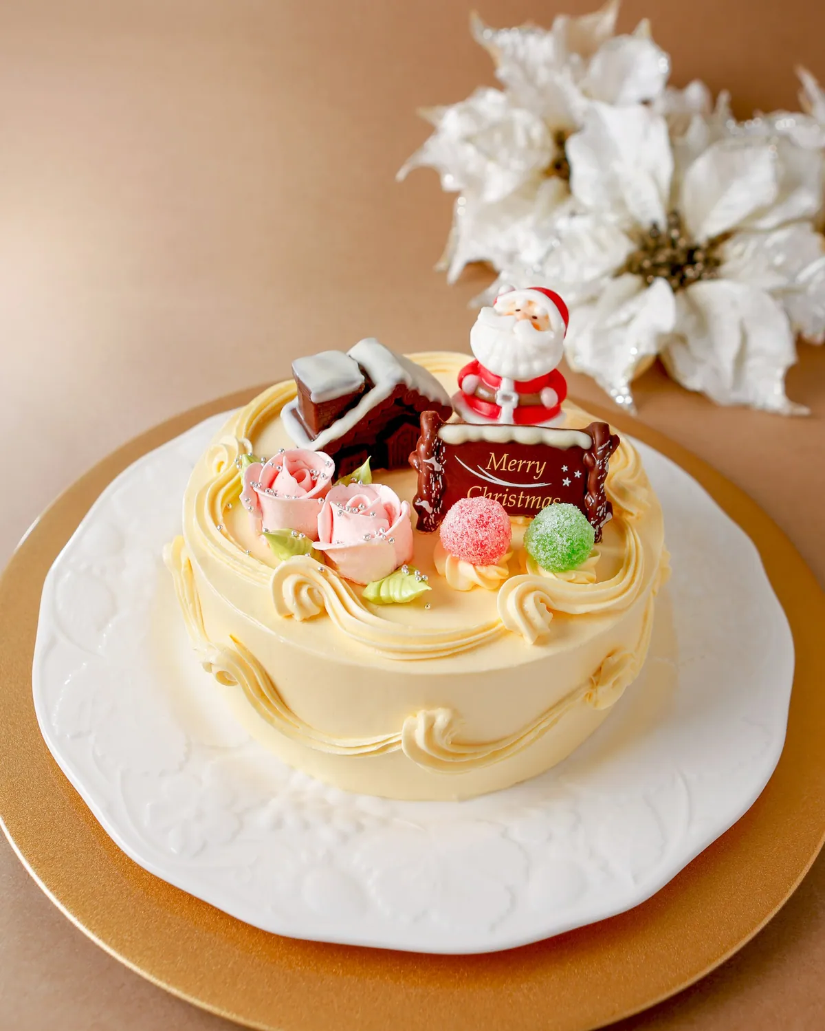 黄色いバタークリームにバラやサンタ、チョコの家を飾ったレトロなクリスマスケーキ