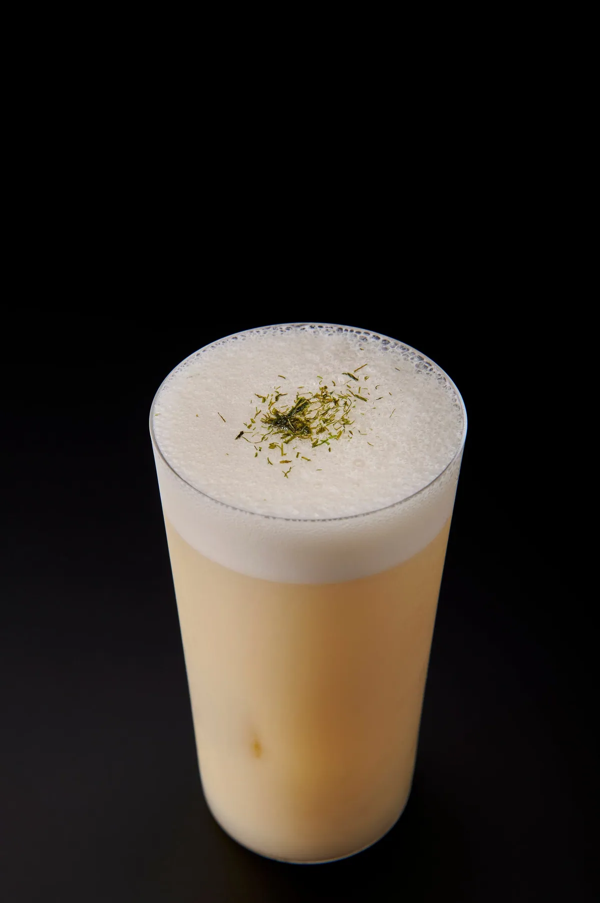 泡をのせた背の高いグラスに入った、乳白色のたこ焼きFizz