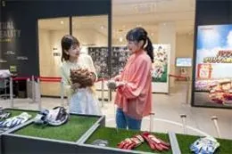 Two women looking at baseball equipment on display at the Koshien Historical Museum
