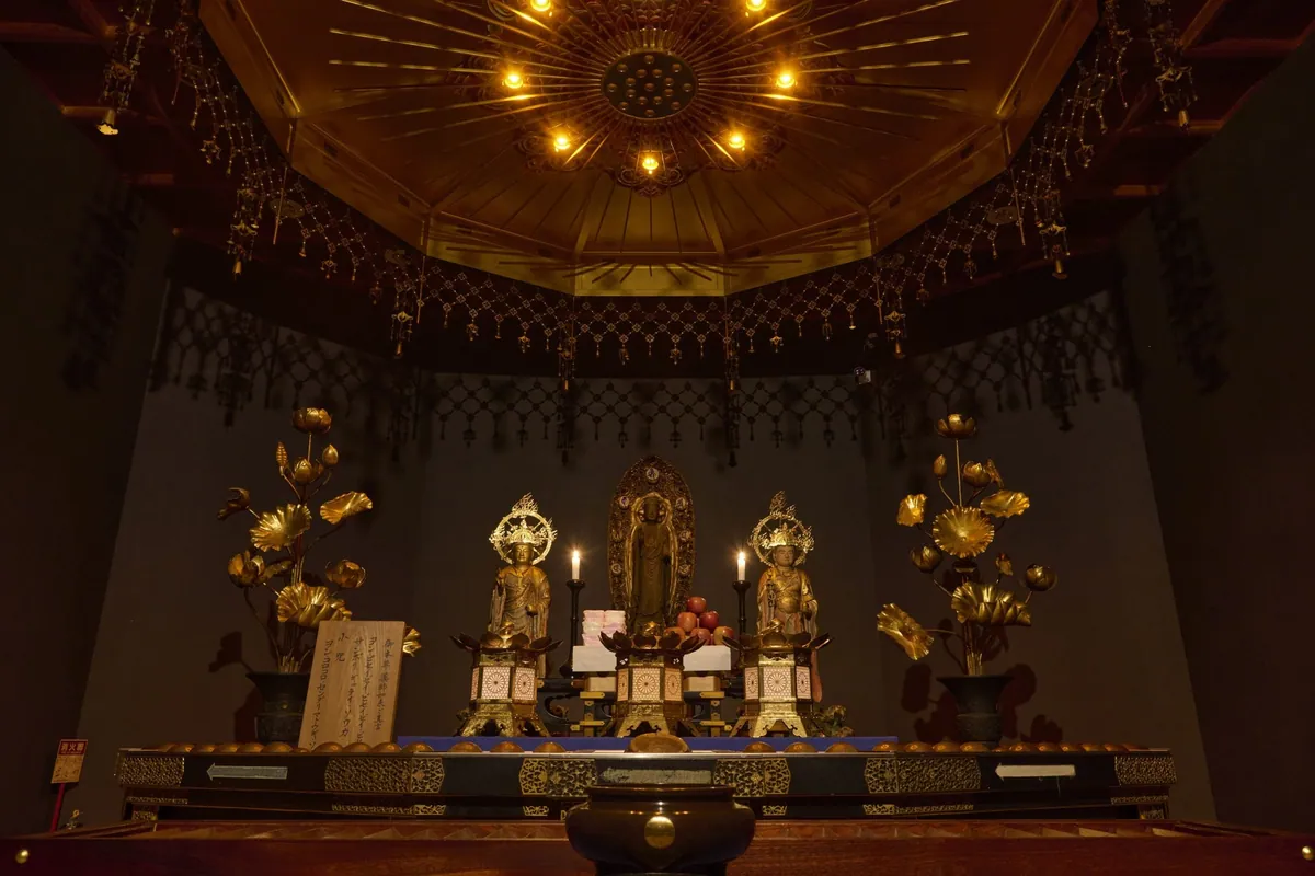 The interior of the Manpaido, with the Yakushi Nyorai statue and gold lotus decorations