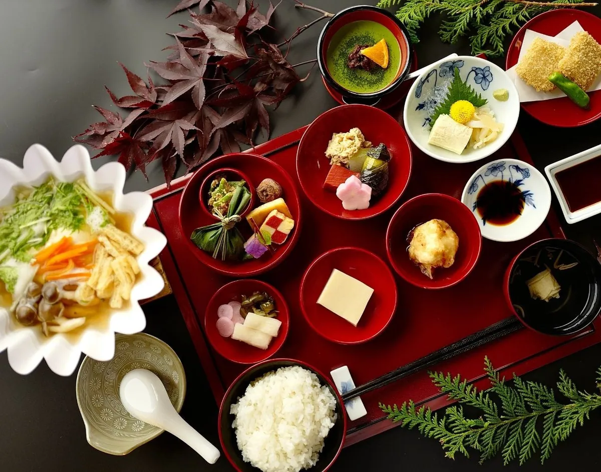 A shojin kaiseki tray with small dishes, soup and rice on a red lacquer tray, decorated with maple leaves