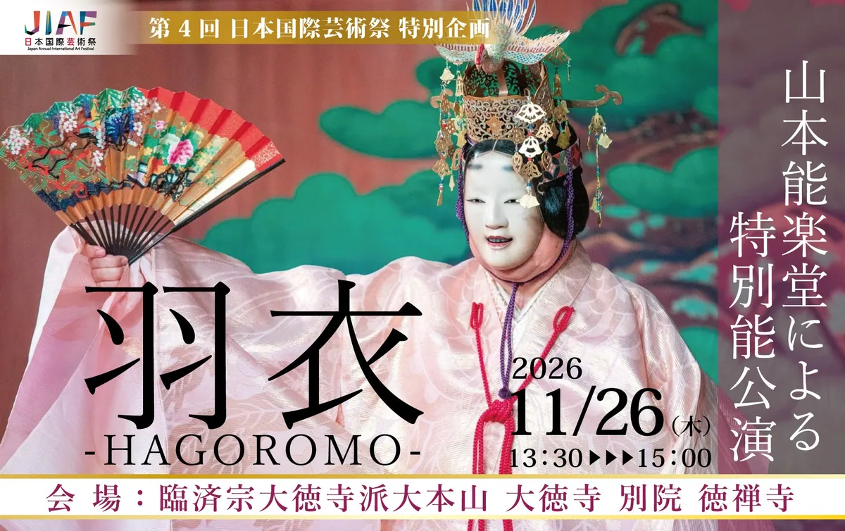 金の天冠と紫の装束をまとい、扇を広げて舞う能の演者