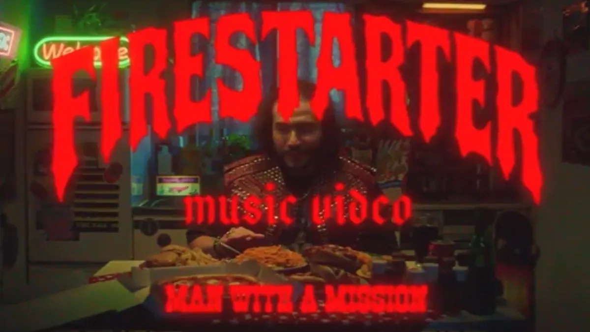 赤い文字で「FIRESTARTER music video」とタイトルが入った、MAN WITH A MISSIONのミュージックビデオの一場面